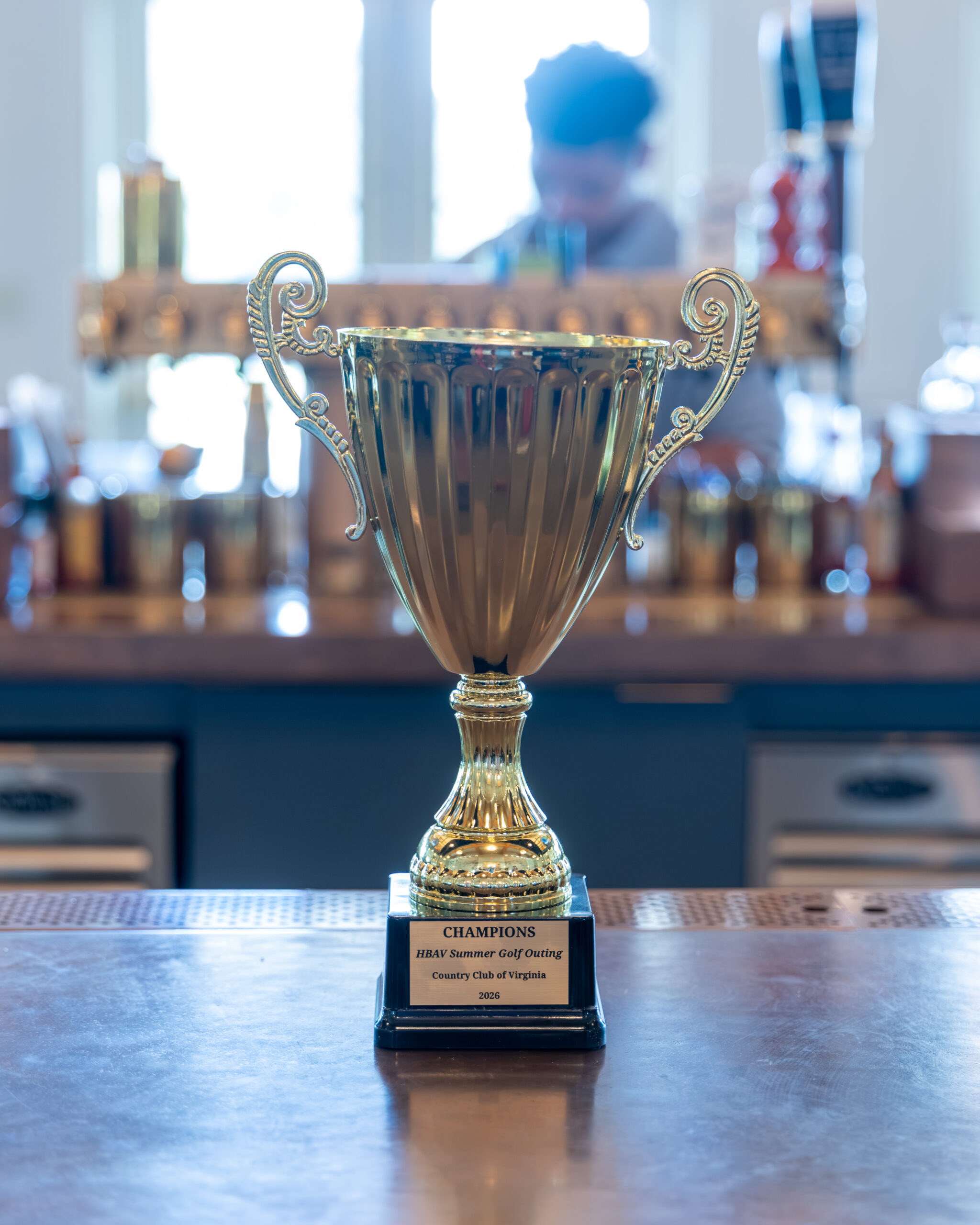 A gold-colored trophy sits on a wooden surface.