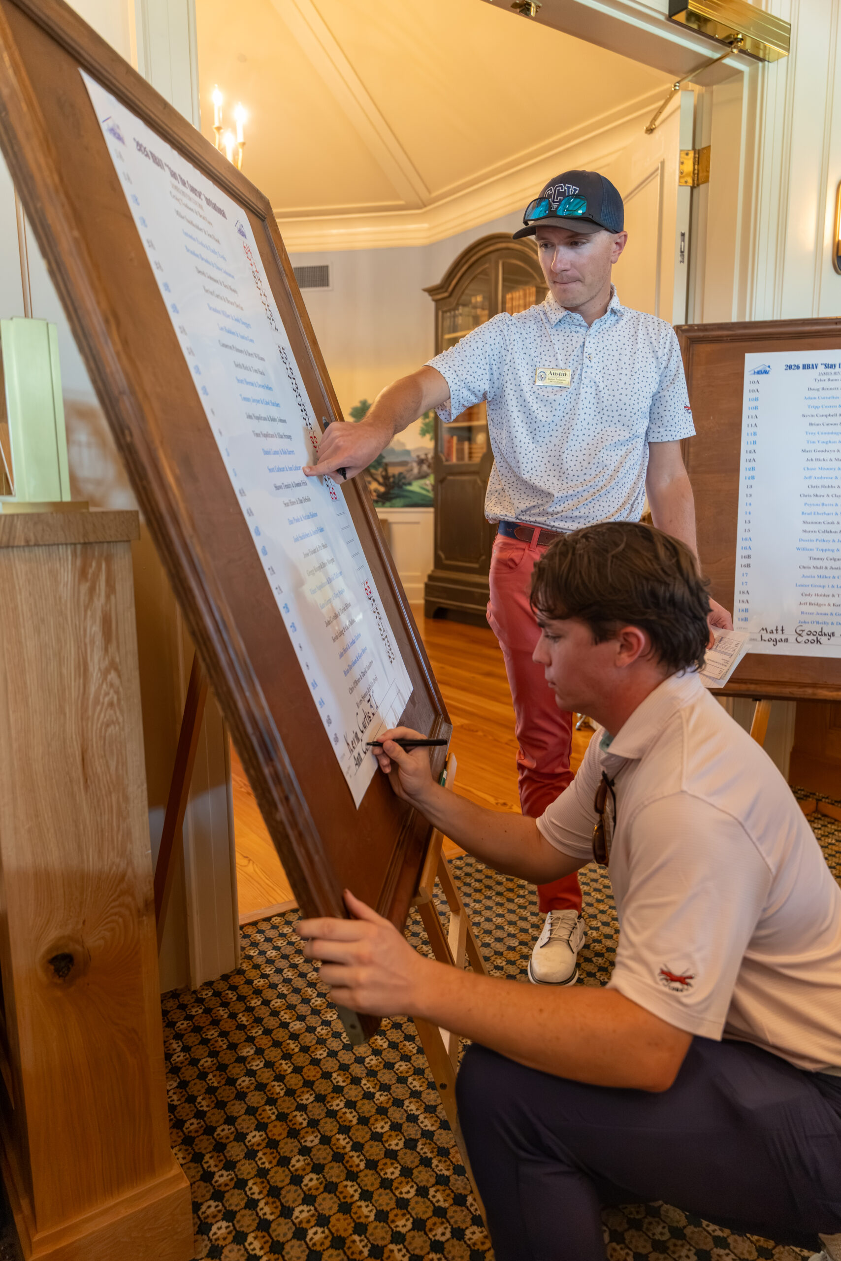 Two men updating a tournament scoreboard at Country Club of Virginia.
