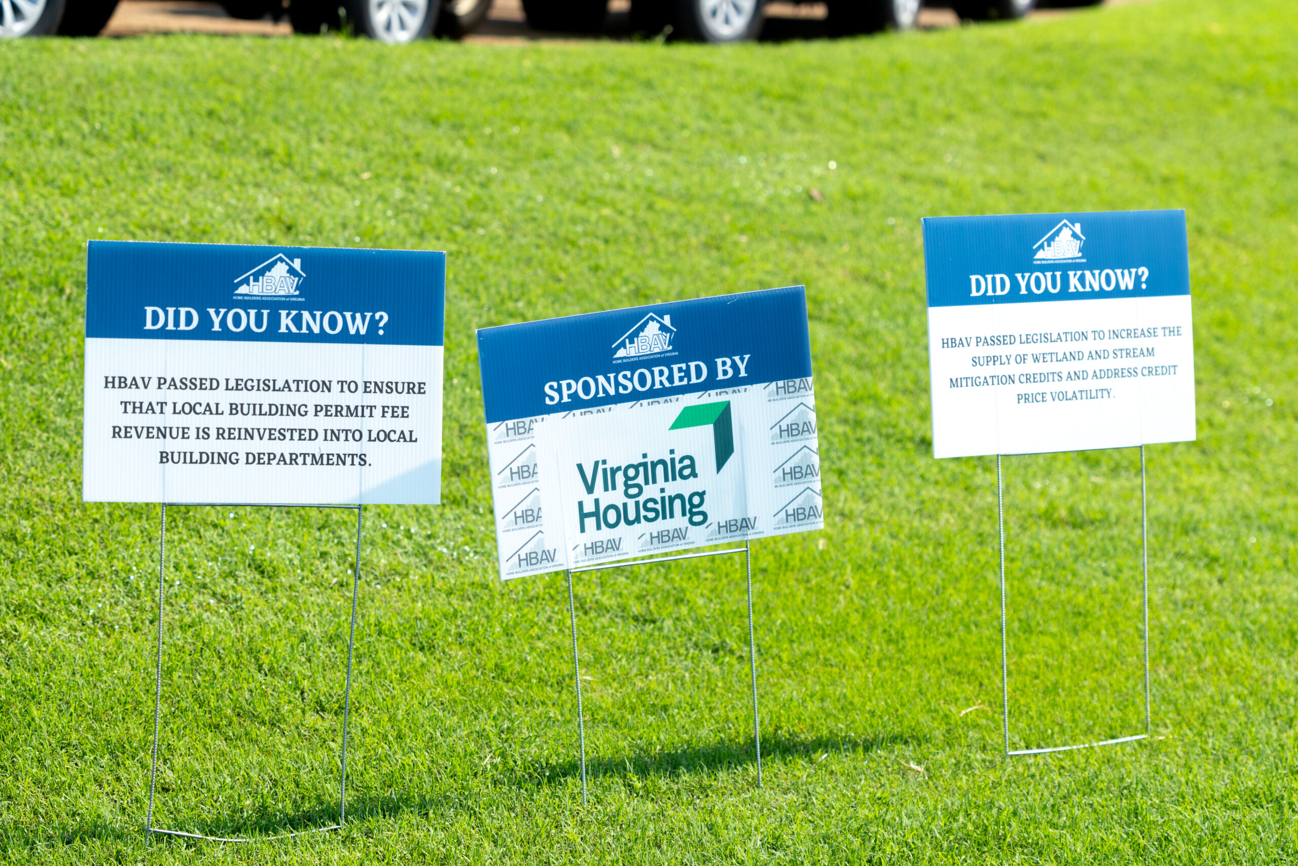 Three signage signs standing on grass with information about HBAV and Virginia Housing.
