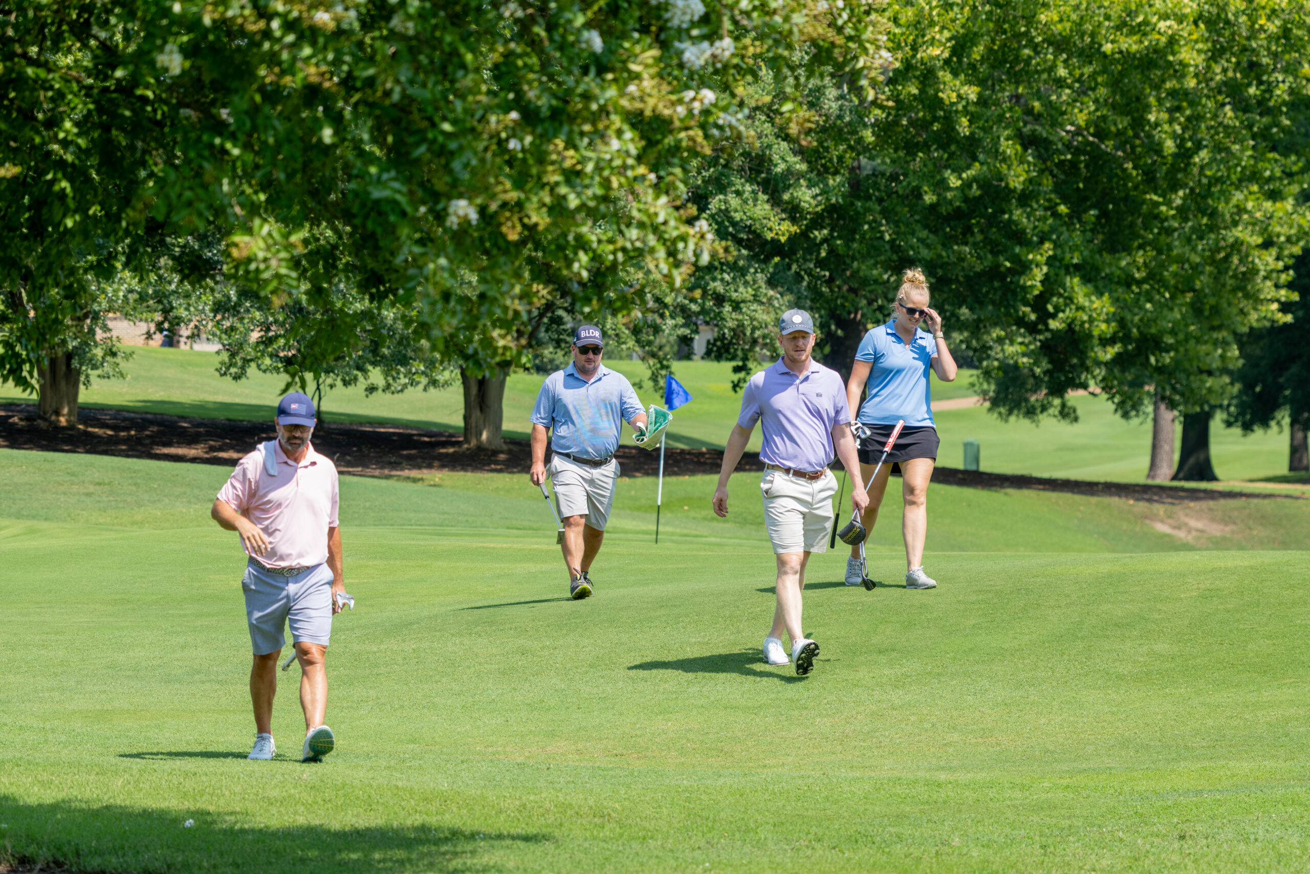 Four golfers playing on a sunny day at Country Club of Virginia.